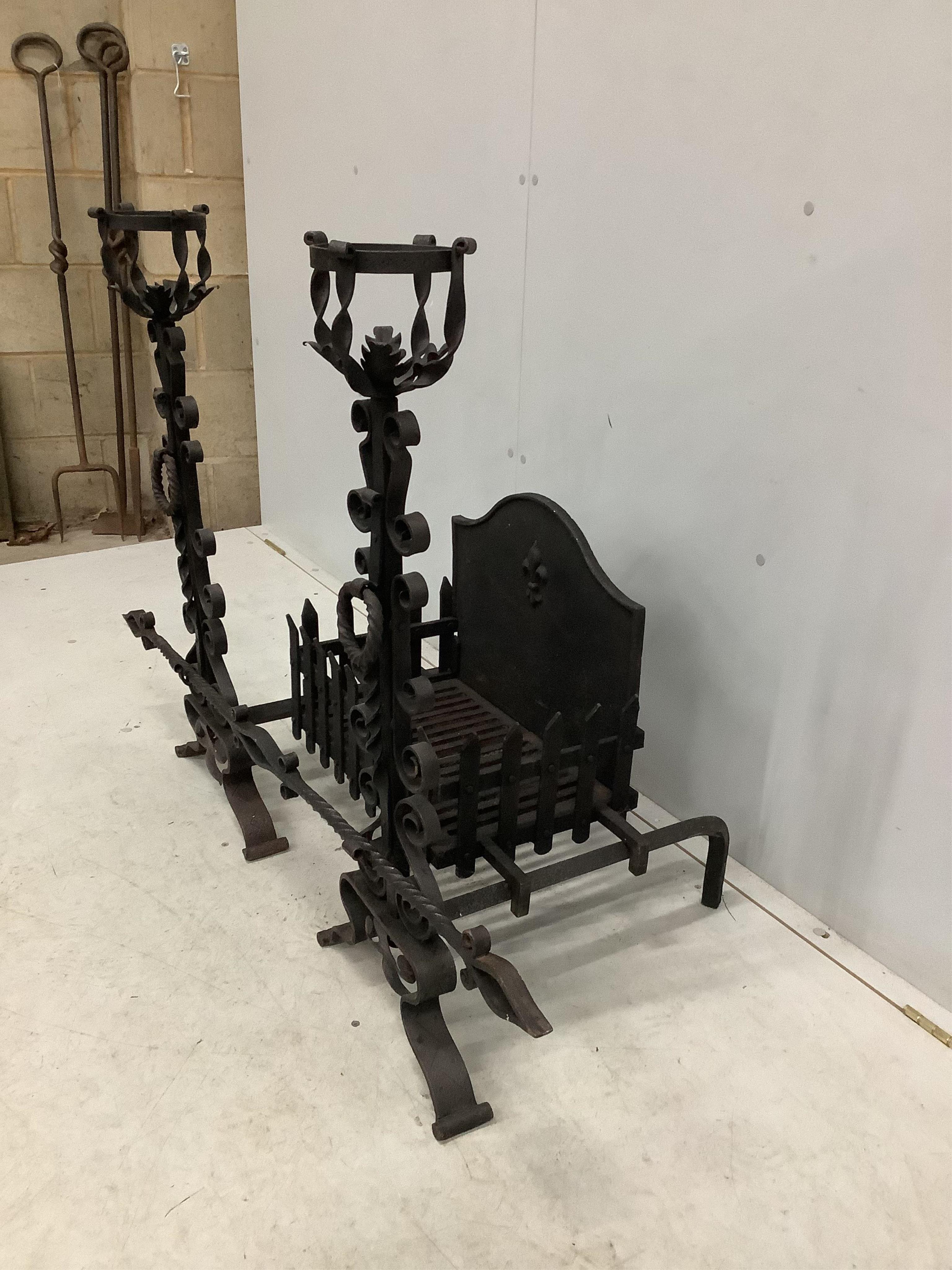 A French wrought iron fire basket with dogs and cast fire back, width 127cm, depth 53cm, height 88cm. Condition - good